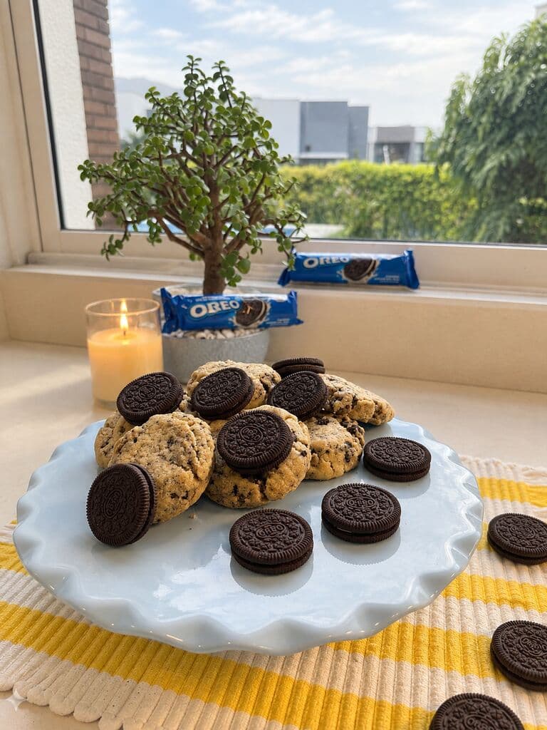 Galletas con trozos de Oreo servidas en un pedestal, junto a galletas Oreo enteras