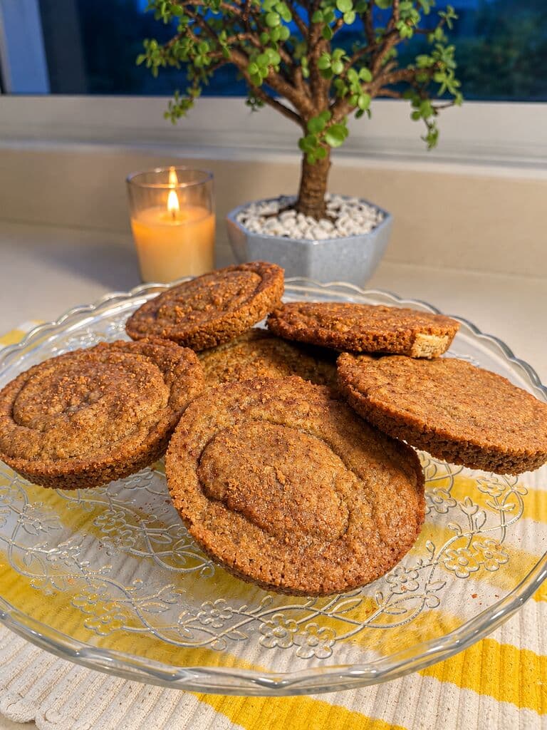 Galletas de rollo de canela en un plato de vidrio junto a la ventana